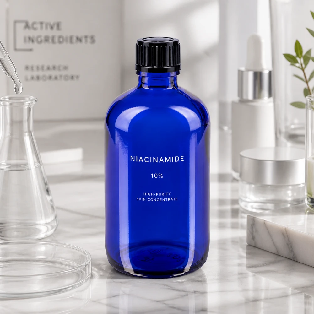 Apoteksflaske blå 100ml dryp v. 1mm sort pc Koboltblå 100 ml apotekerflaske med etiket med niacinamid på marmoroverflade i et laboratoriemiljø