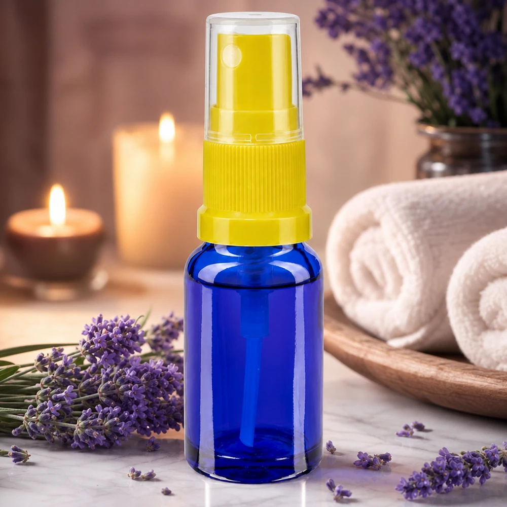Aromaterapi-tilbehør: blå 30 ml sprayflaske med gul sprøjtehoved ved siden af lavendelblomster