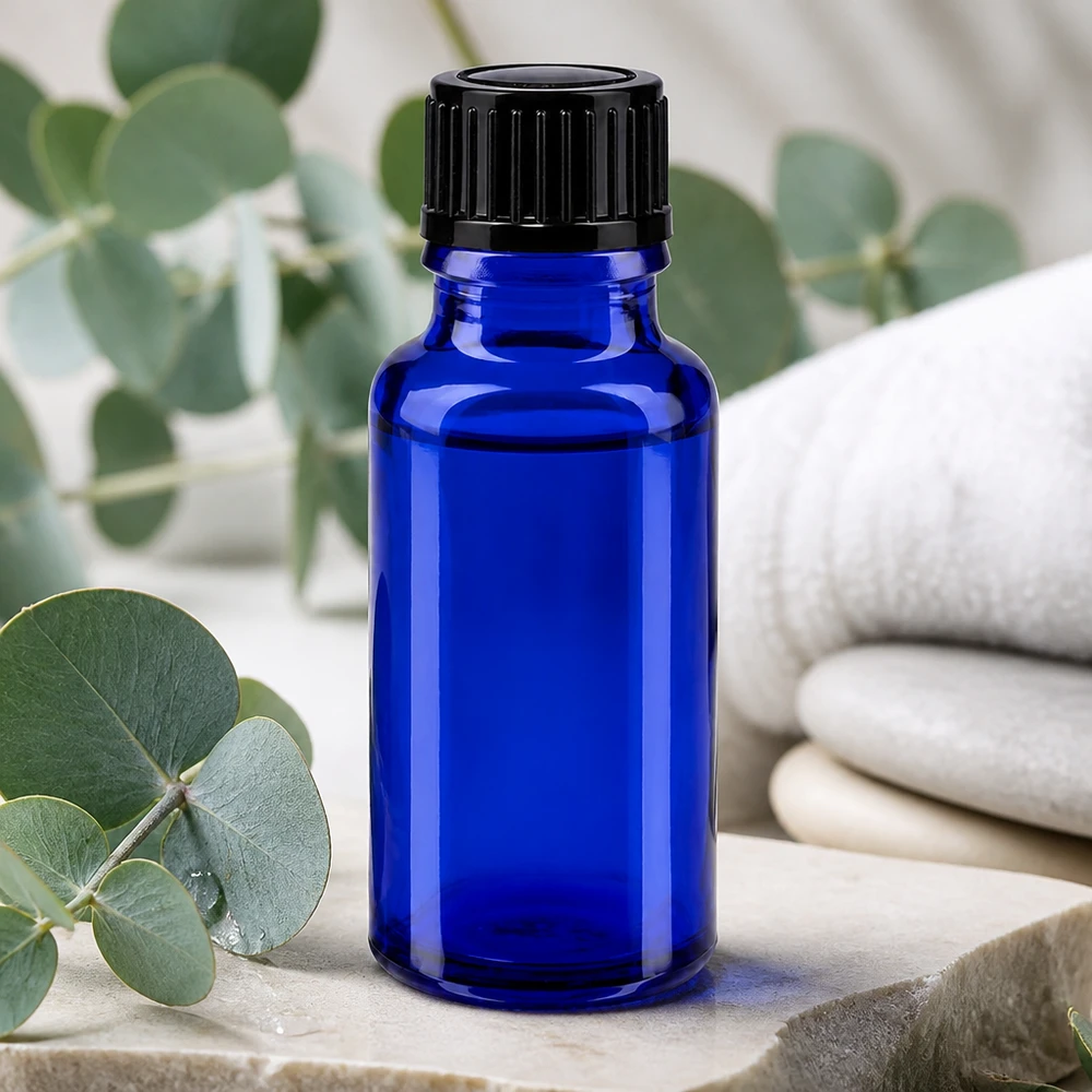 Apoteksflaske blå 20ml skruelåg sort pc Lille blå apotekerflaske på 20 ml med sort låg på natursten med eukalyptus