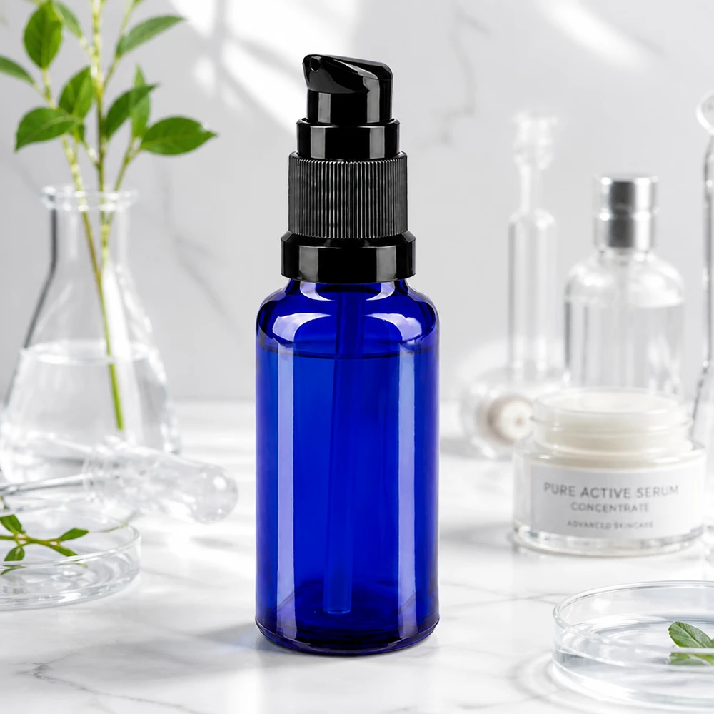 Apoteksflaske blå 20ml pumpehætte sort St Blå 20 ml pumpeflaske af apotekerglas med sort pumpehoved på marmor ved siden af laboratorieglasudstyr