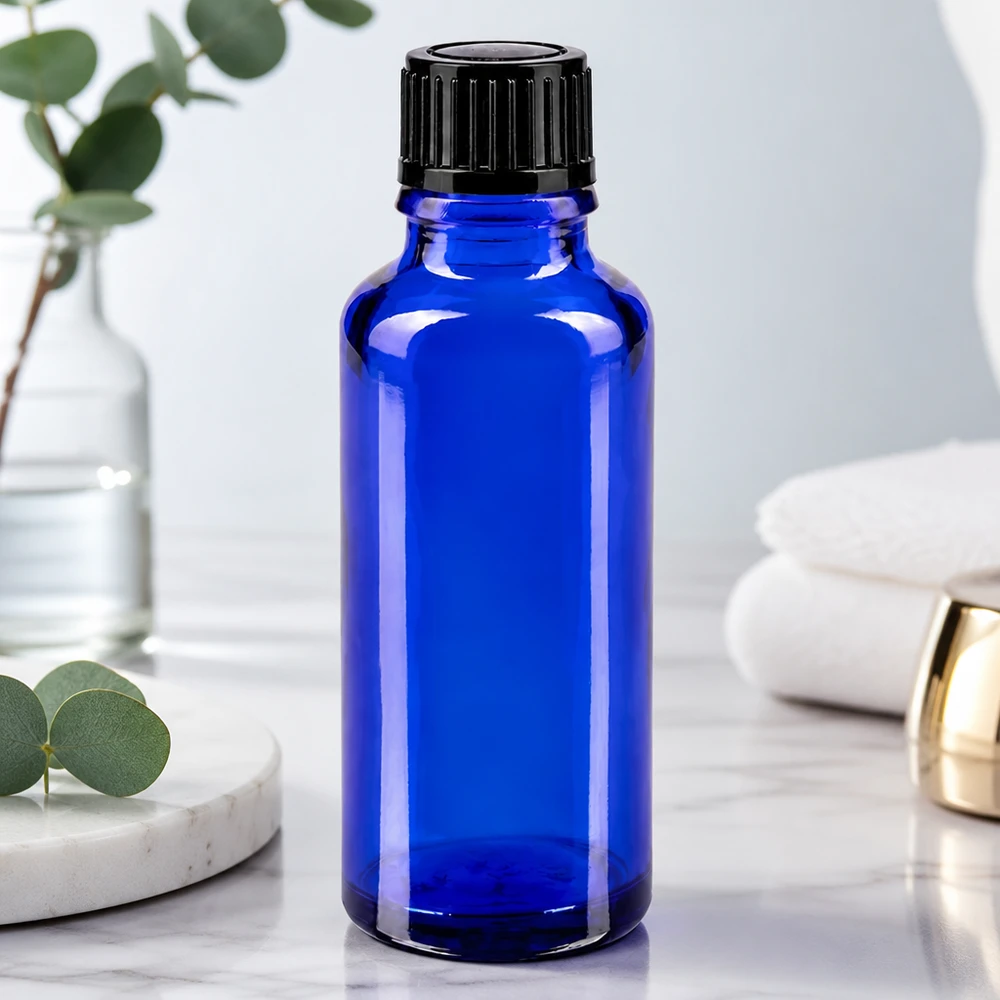 Apoteksflaske blå 30ml skruelåg sort pc Koboltblå 30 ml glasflaske med sort skruelåg på en hvid marmoroverflade