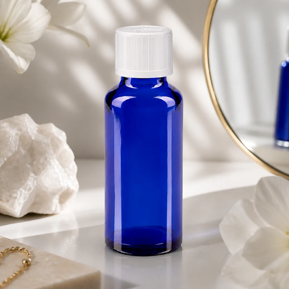 Slank 30 ml apotekerflaske af koboltblåt glas med hvid børnesikret låg