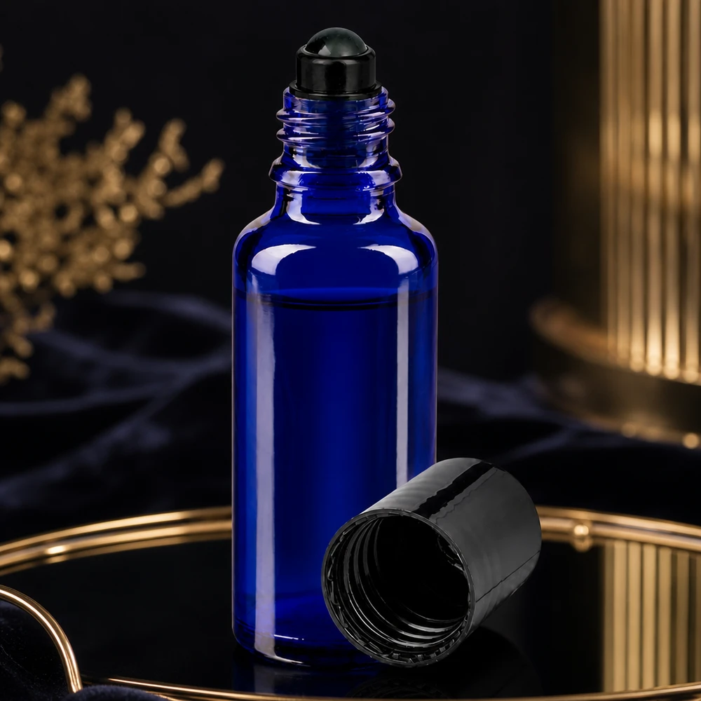 Apoteksflaske blå 30 ml roll-on-hætte sort Blå 30 ml roll-on-flaske med åbent sort skruelåg på et gyldent fad