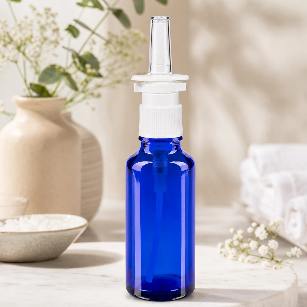 Nærbillede af en 30 ml næsesprayflaske i koboltblå med hvid skruelågspumpe og gennemsigtig plastspids