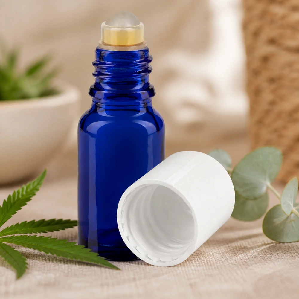Blå 10 ml roll-on-flaske med hvidt låg ved siden af hamp- og eukalyptusblade på linnedstof