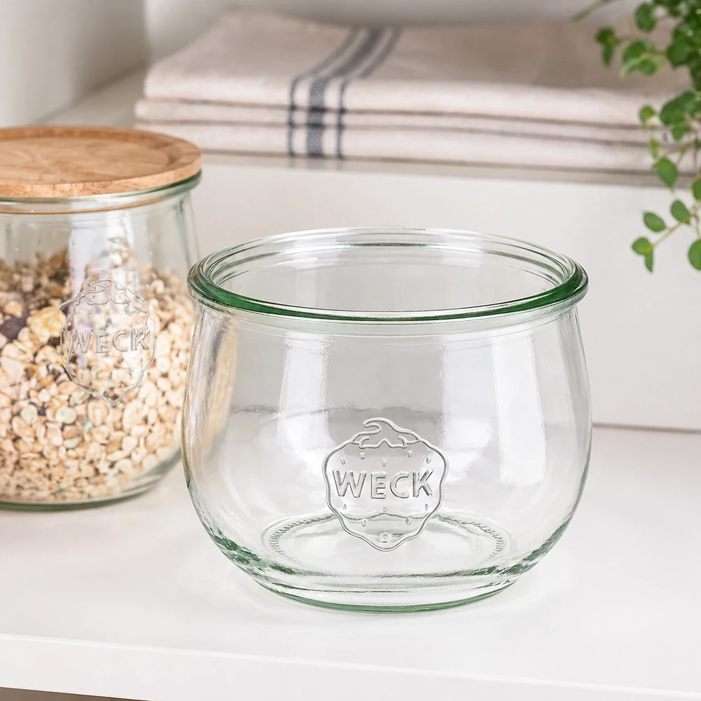 580 ml tulpanglas WECK RR100 580 ml WECK tulipankrukke RR100 konserveringskrukke transparent med logo på hvid køkkenbordplade ved siden af opbevaringskrukke