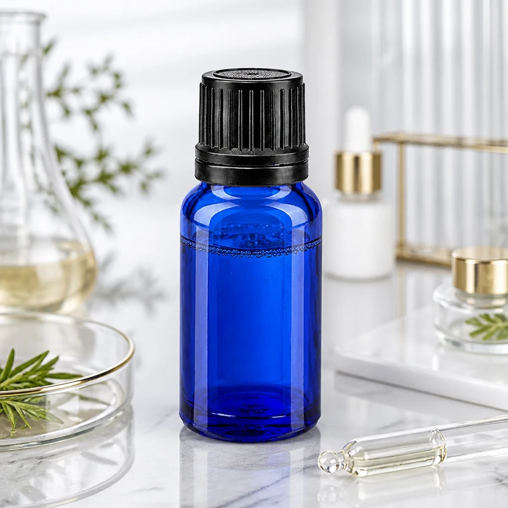 Apoteksflaske blå 10ml dryp v. Pr. 1mm sort OV 10 ml blå dråbeflaske af UV-beskyttende glas med sort originalitetslukning på marmor