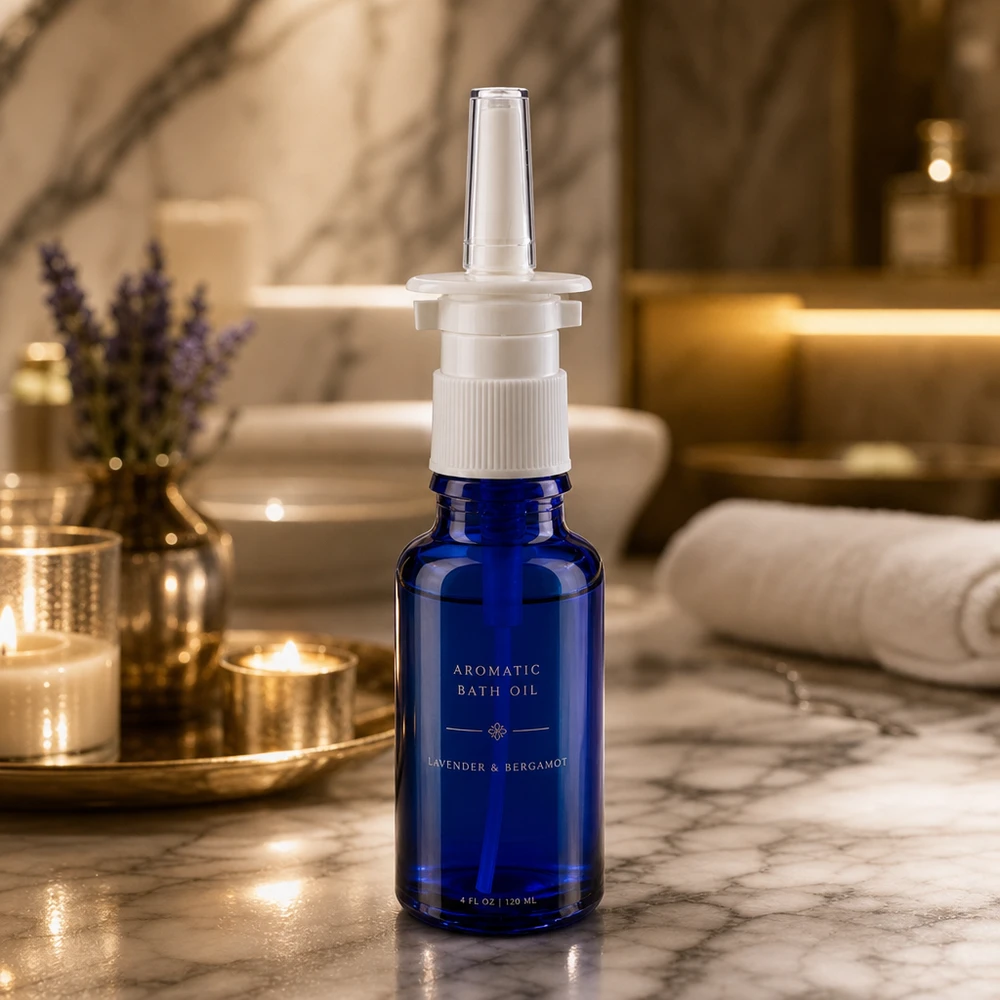 Apoteksflaske blå 20 ml næseforstøver hvid St Apotekflaske til næsespray, 20 ml, i koboltblå med hvid pumpe foran et luksuriøst badeværelsesmiljø