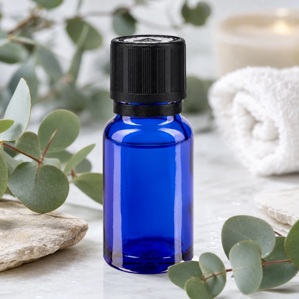 Apotfl. blå 10ml dryp v. Pr. 1mm s. KiSi Bliw OV Koboltblå 10 ml apotekerflaske med sort OV-lukning på marmor mellem eukalyptusgrene