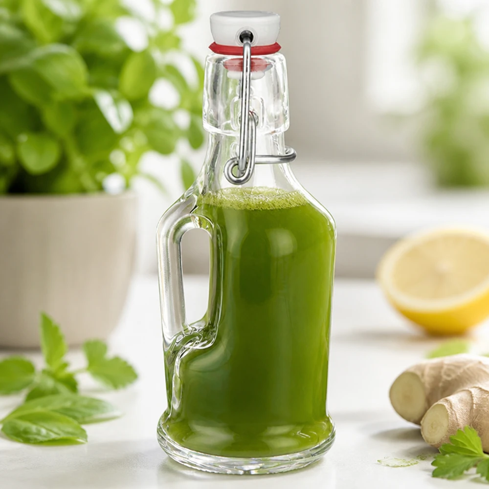 200 ml glasflaske »Bertha« og porcelænshængelåg UNiTWIST® Glasflaske Bertha 200 ml fyldt med grøn smoothie ved siden af ingefær og citron Køkkenscene UNiTW-svingprop