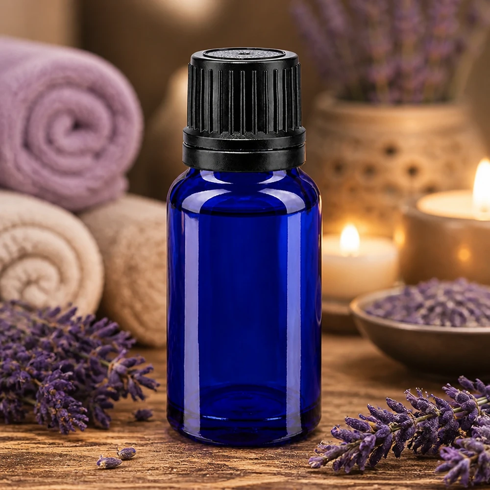Apoteksflaske blå 10ml skruelåg sort hældeprop r. OV Lille 10 ml blå glasflaske med sort originalprop omgivet af lavendelblomster og stearinlys