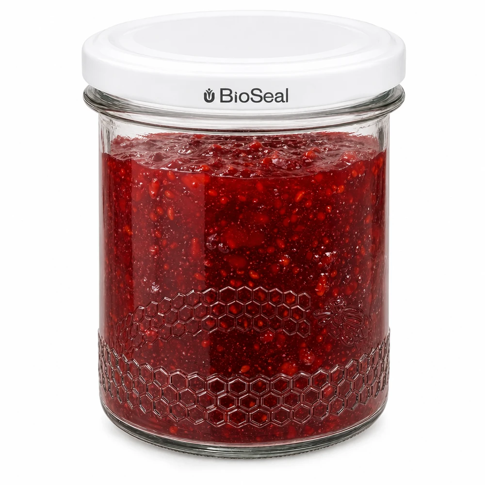 560 g honningglas med hvidt BioSeal UNiTWIST-låg BioSeal-konservesglas 400 ml fyldt med rød marmelade viser lufttæt forsegling og honningkageprægning på glassets kant