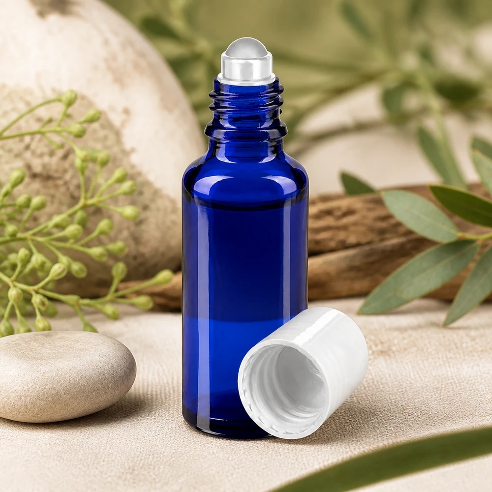 Blå 30 ml apotekerflaske af glas med ruller i rustfrit stål og hvid skruelåg på natursten