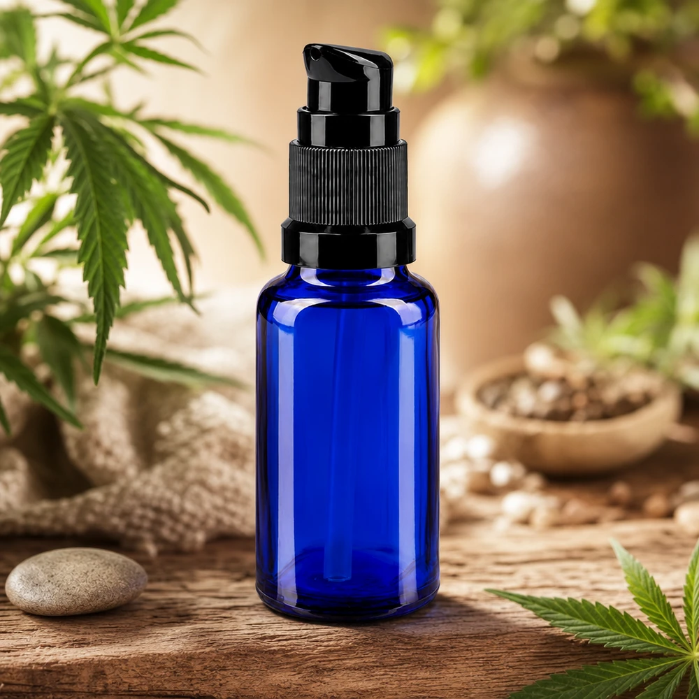 Koboltblå 20 ml pumpeflaske af apotekerglas med sort pumpehoved foran cannabisplanter