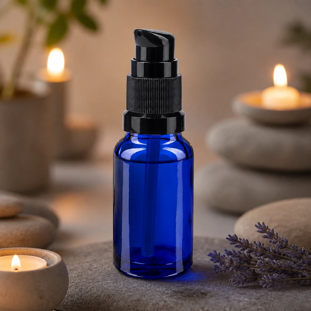 Blå 10 ml apotekerflaske med sort pumpehætte ved siden af lavendel og stearinlys