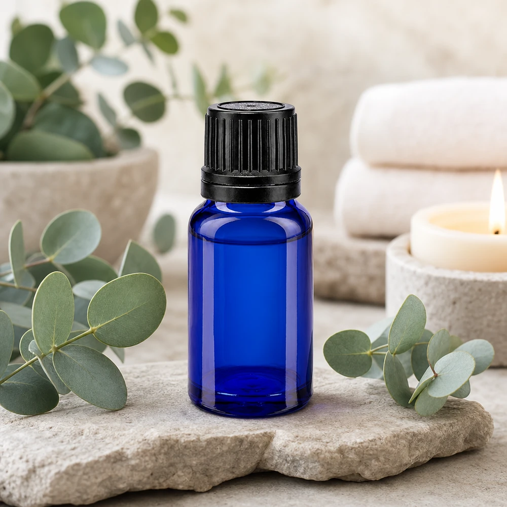 Apoteksflaske blå 10ml skruelåg sort hældeprop r. OV Blå 10 ml dråbeflaske med sort skruelåg på natursten med eukalyptusgrene