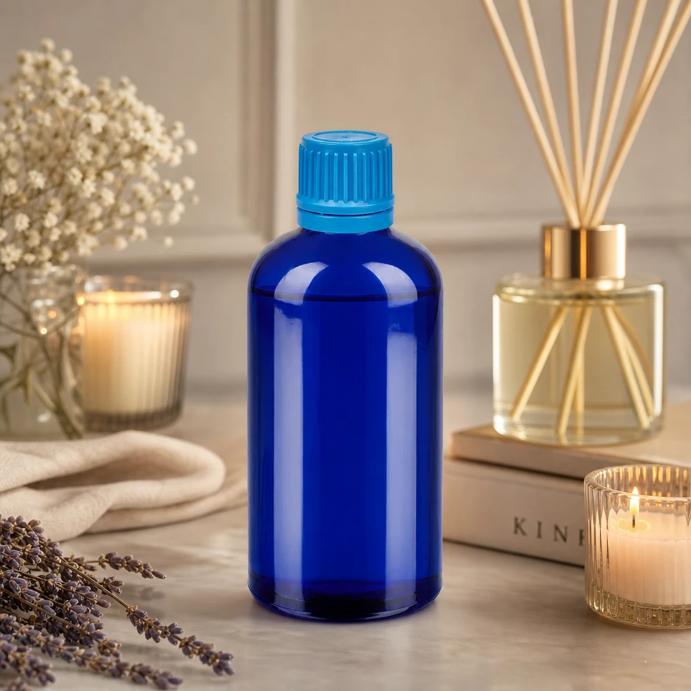 Stilfuld blå glasflaske 100 ml med UT18-gevind, ideel til æteriske olier og wellness-produkter