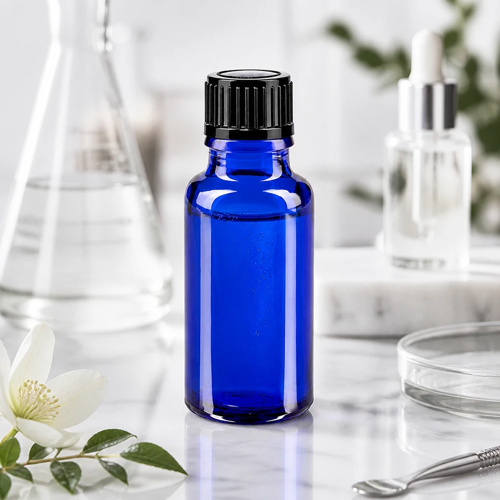 Apoteksflaske blå 20ml dryp v. 1mm sort pc Koboltblå 20 ml glasflaske med sort børnesikret låg på marmor