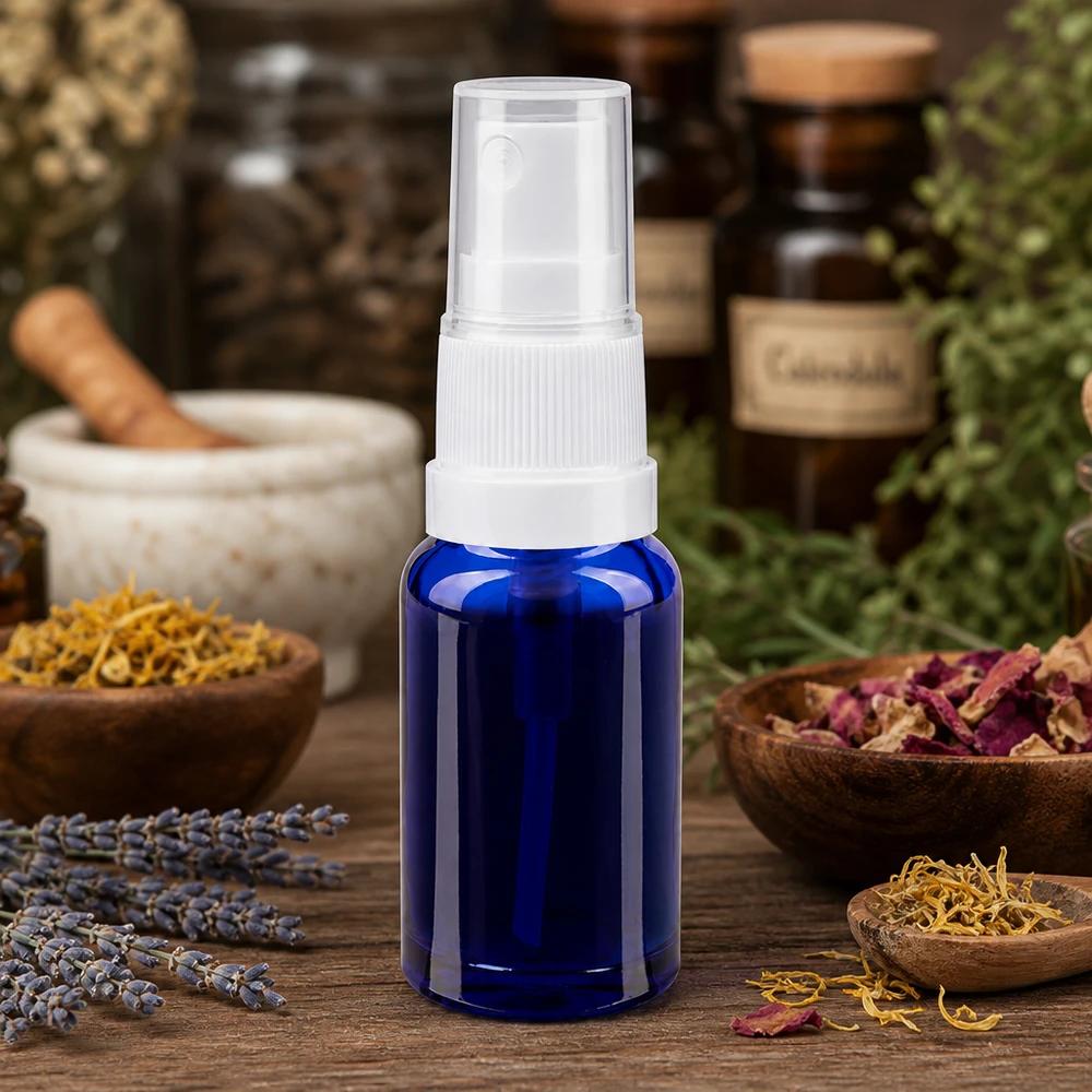 Apoteksflaske blå 10ml spraytop hvid 10 ml sprayflaske af blåt apotekerglas med hvid forstøver omgivet af lægeurter og lavendel