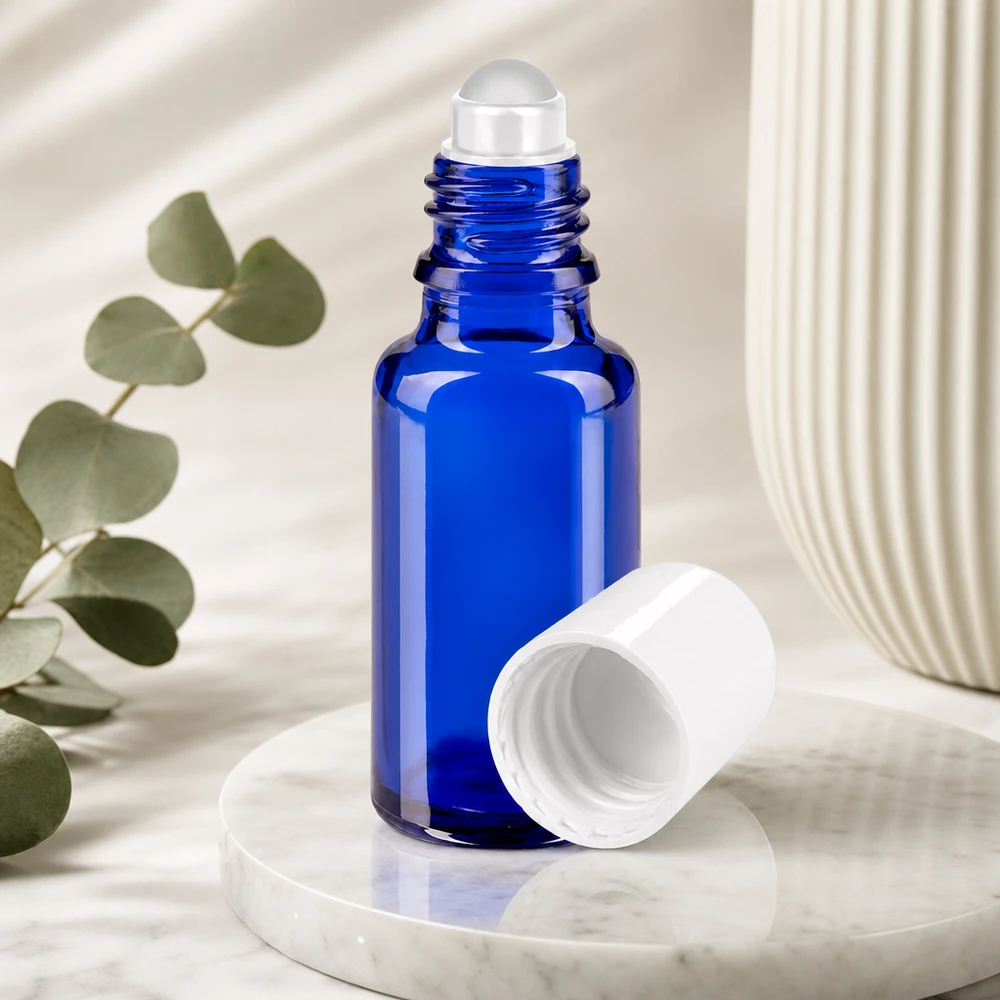 Apoteksflaske blå 20 ml roll-on-hætte hvid Blå 20 ml roll-on-flaske af apotekerglas med afmonteret hvidt låg på marmor