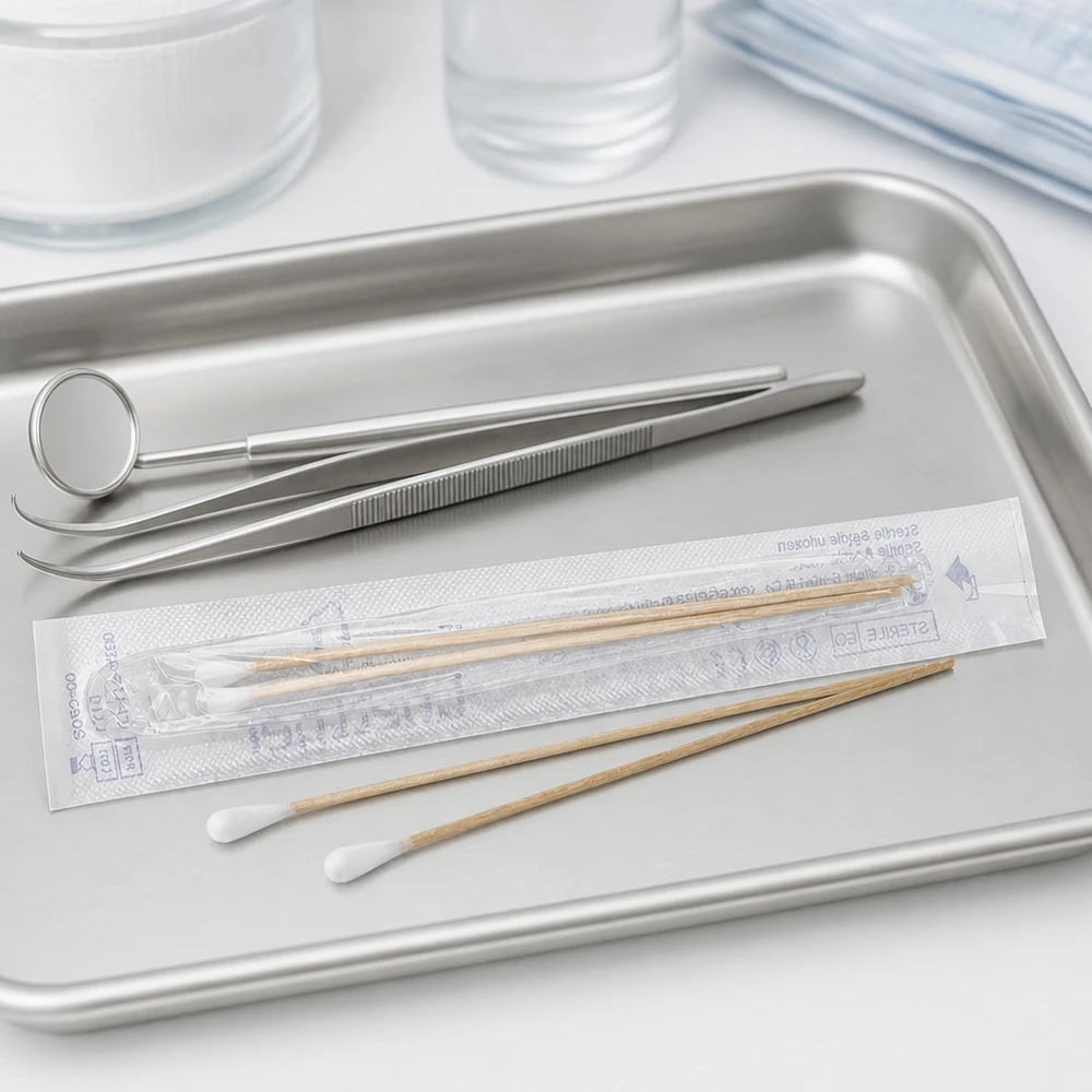 Vatpinde STERIL (2 stk.) Sterile vatpinde på et medicinsk bakke ved siden af tandlægeinstrumenter og en pincet