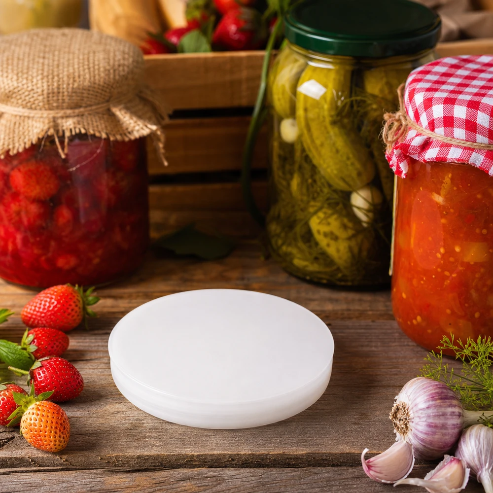 Hvidt UNiTWIST silikonelåg RR80 mellem syltede agurker på dåse og friske ingredienser rustikt køkken