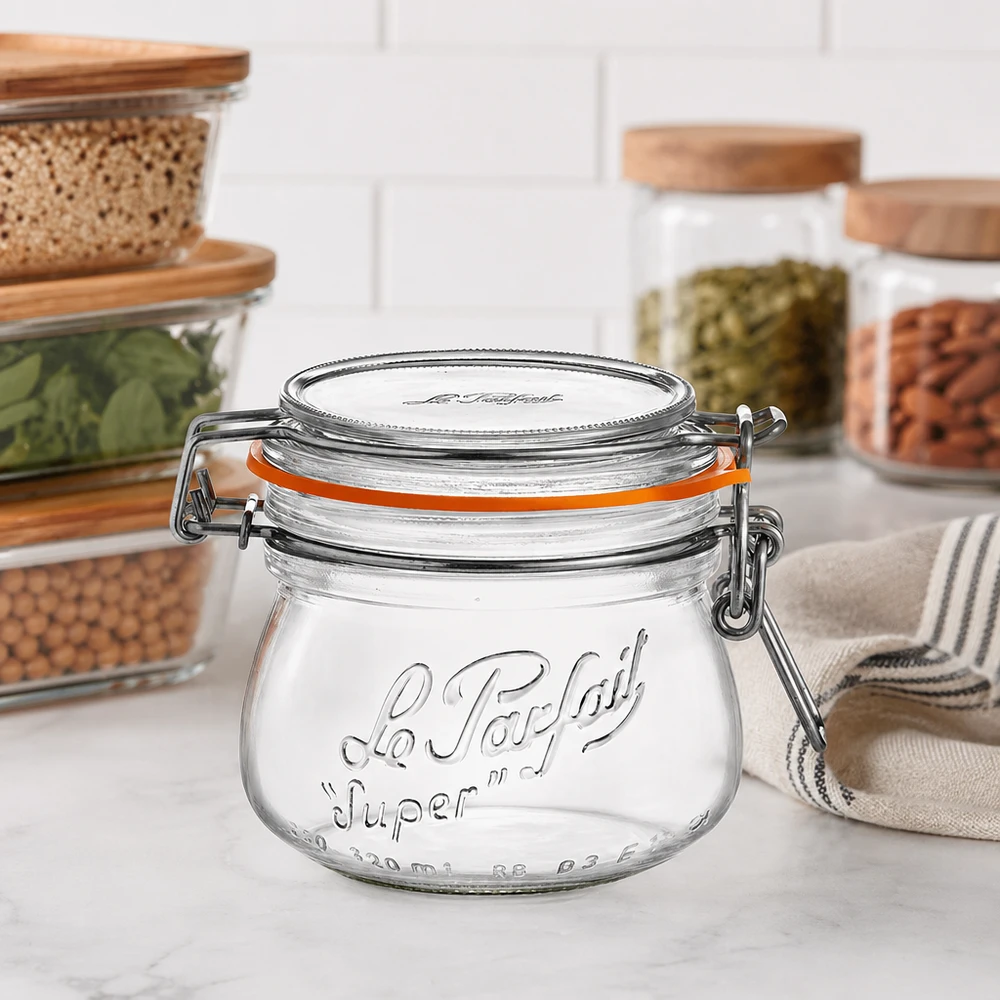 Le Parfait® glas 250 ml Ø70 mm opbevaring 250 ml Le Parfait Super opbevaringskrukke med svingtop og gummiring på køkkenbordet ved siden af andre opbevaringskrukker