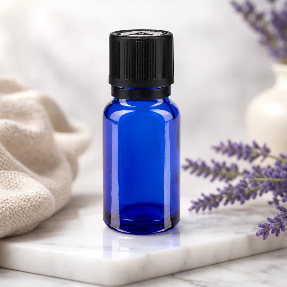 Blå 10 ml dråbeflaske med sort KiSi-låg ved siden af lilla lavendelblomster på en marmorplade