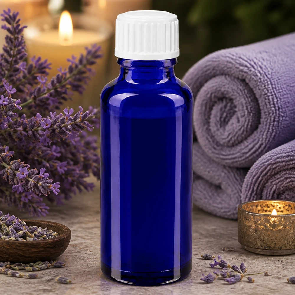 30 ml blå glasflaske med hvid dråbeindsats på 3 mm omgivet af lavendelblomster og spa-tilbehør