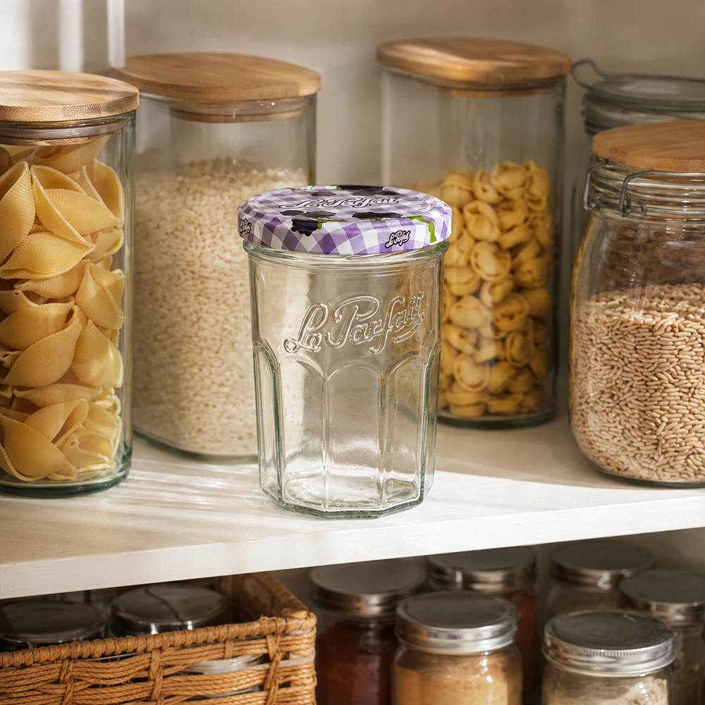 Le Parfait® Jam 385 ml Ø82 mm syltetøjsglas 385 ml syltetøjsglas med skruelåg Le Parfait på køkkenhylden mellem opbevaringsglas med pasta og morgenmadsprodukter