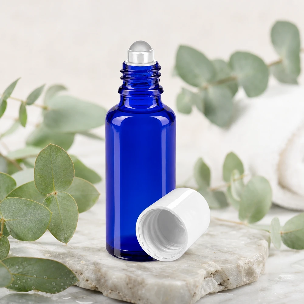 Apoteksflaske blå 30 ml roll-on-hætte hvid 30 ml roll-on-flaske af koboltblåt apotekerglas med hvid hætte og eukalyptusgrene