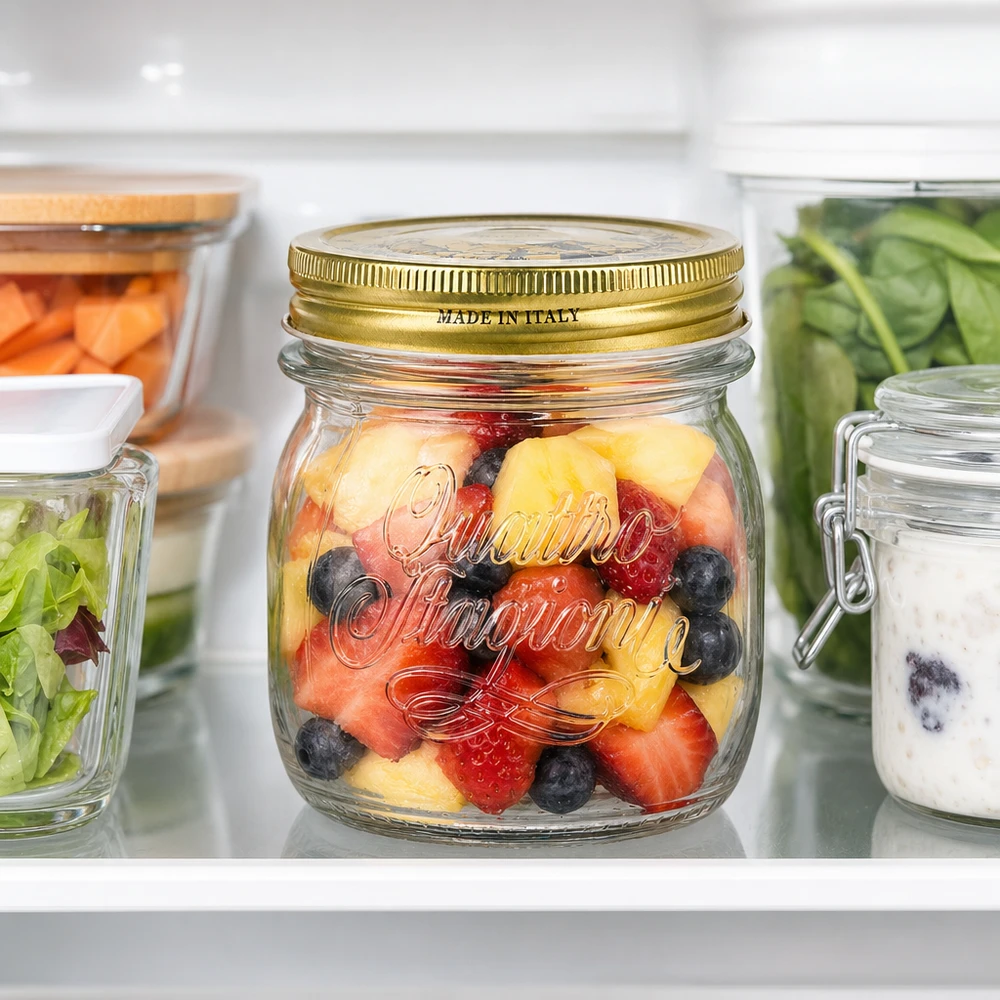 250 ml rundt glas "Quattro Stagioni" med låg 250 ml rund krukke Quattro Stagioni med gyldent låg fyldt med frugtsalat i køleskabet Made in Italy