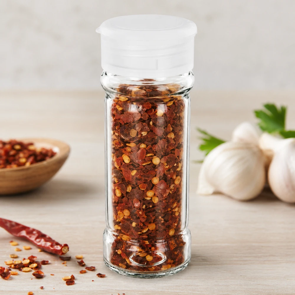Salt-/krydderikrukke 100 ml med strøer, hvid Lille krydderiglas på 100 ml med hvid strøer, fyldt med røde chiliflager og hvidløg i baggrunden