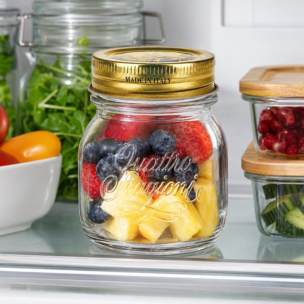 150 ml rundt glas "Quattro Stagioni" med låg 150 ml rundt glas Quattro Stagioni med gyldent låg fyldt med bær og ananas i køleskabet
