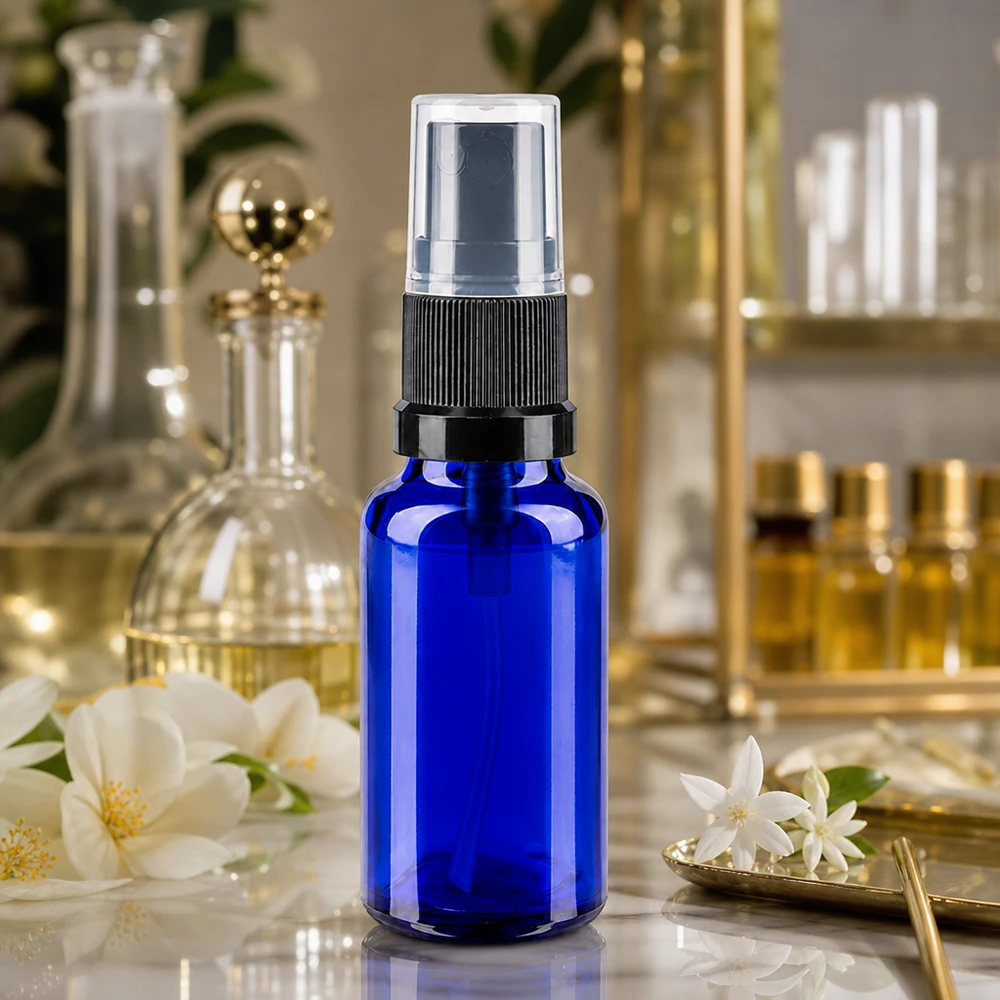 Blå 20 ml sprøjteflaske af apotekerglas med sort forstøver og gennemsigtig beskyttelseskappe