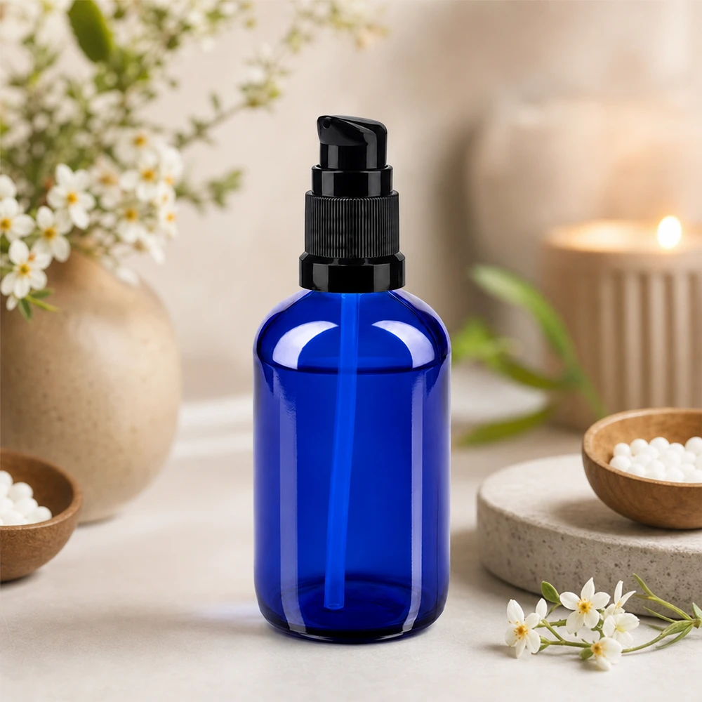 Cylindrisk 100 ml pumpeflaske af koboltblåt apotekerglas med sort doseringspumpe