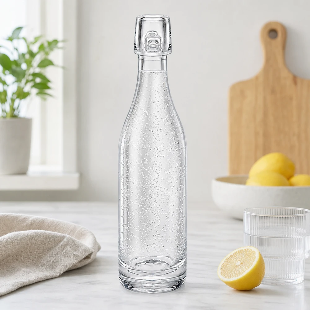 50 ml glasflaske uden skruelåg UNiTWIST 50 ml glasflaske UNiTWIST fyldt med danskvand i moderne køkken ved siden af citroner og glas hvid bordplade