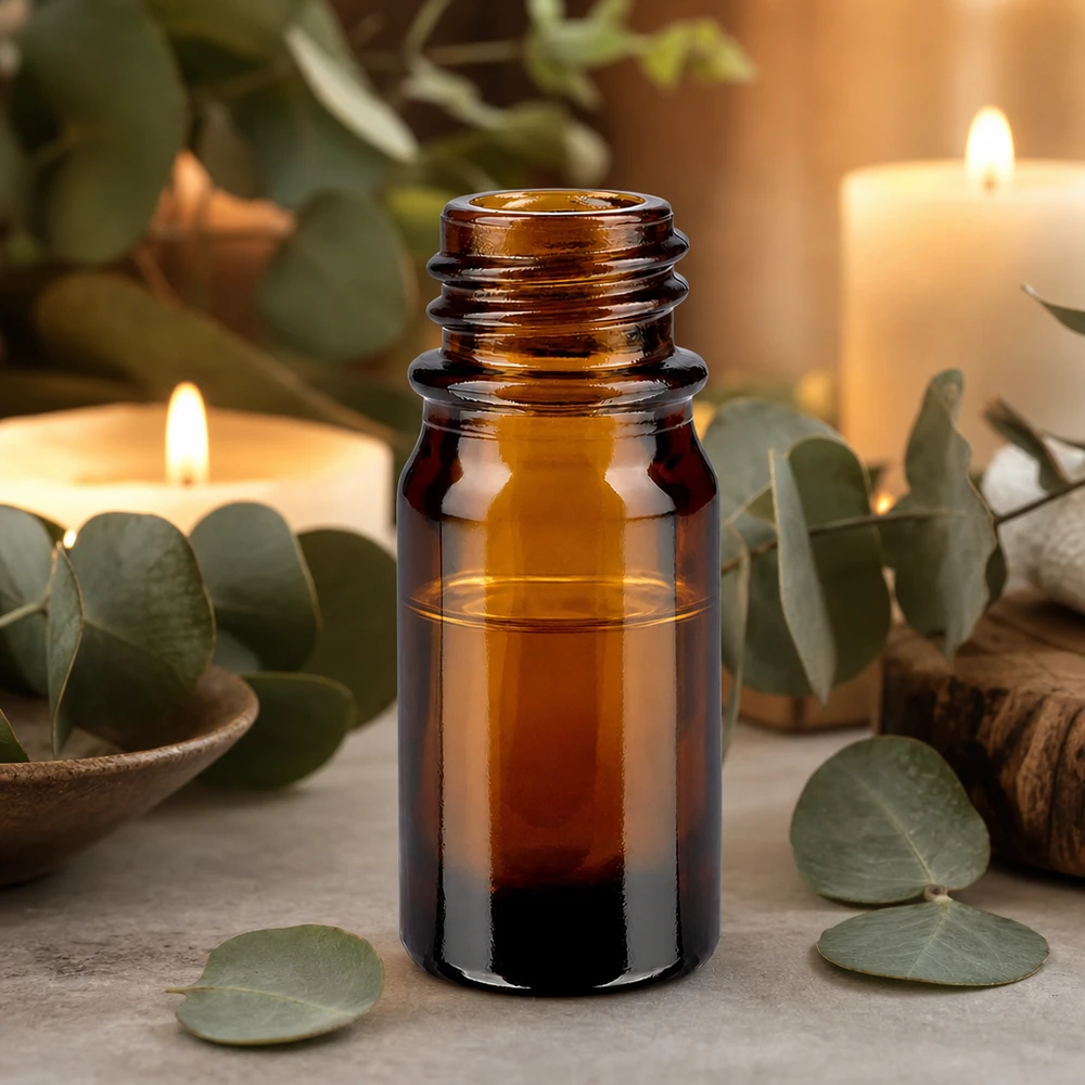 Dropperflaske 5 ml DIN 18 lavet af ravfarvet glas 5 ml brun apotekerflaske ApoGlas med eukalyptusblade og stearinlys til afslappende aromaterapi.