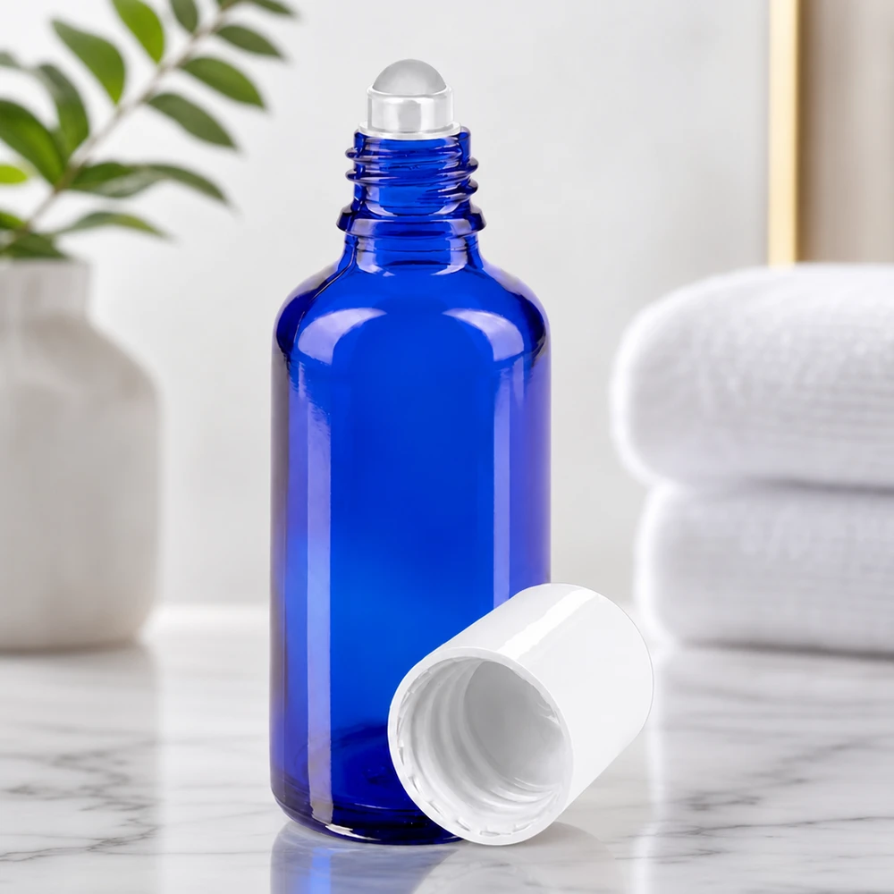 Cylindrisk 50 ml apotekerflaske i blåt med påsat rullekugle og åbent hvidt låg
