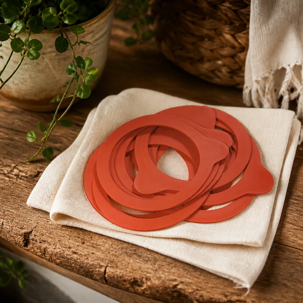 Kogende ring af naturgummi RR60 Konserveringsringe RR60 naturgummi orange på hørdug rustikt træbord med plante naturlig køkkenatmosfære