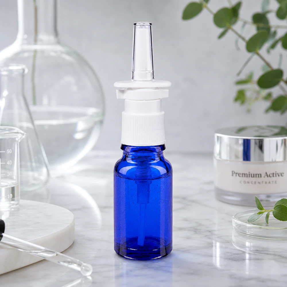 Apoteksflaske blå 10 ml næseforstøver hvid St Kompakt 10 ml næsesprayflaske i blå med hvid pumpe på marmoroverflade