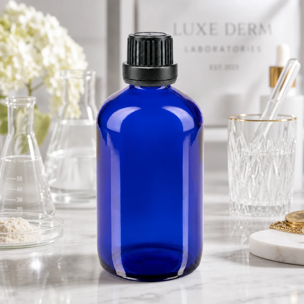 Apoteksflaske blå 100 ml skruelåg sort tæt OV Blå glasflaske på 100 ml med sort originalitetslukning foran baggrunden fra Luxe Derm Laboratorier