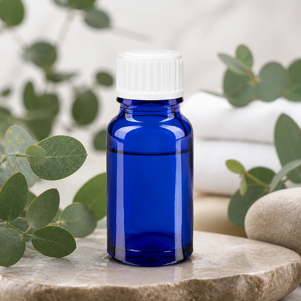 Koboltblå 10 ml apotekerflaske med hvidt dråbehoved på natursten med eukalyptus
