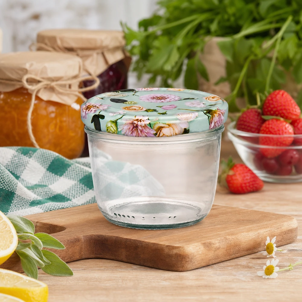 230 ml væltet glas + BasicSeal låg Blume mint UNiTWIST 230 ml glas med blomstret BasicSeal-låg på træplade, køkkenscene med marmelade, jordbær og krydderurter