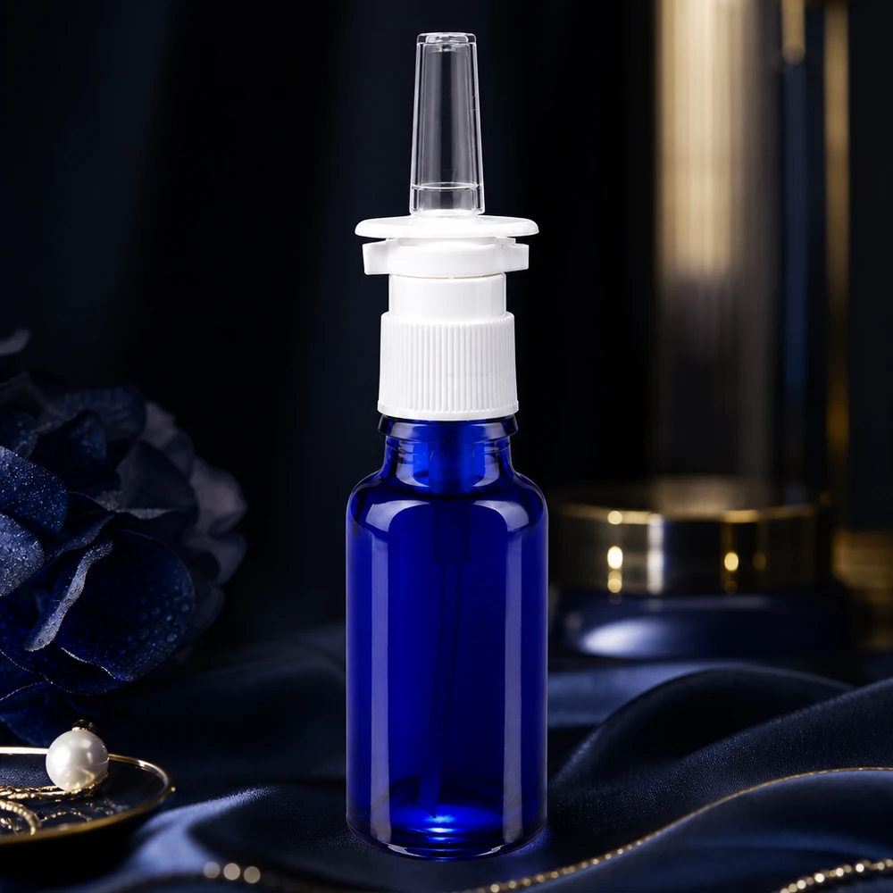 Apoteksflaske blå 20 ml næseforstøver hvid St 20 ml blå næsesprayflaske af apotekerglas med hvid pumpemekanisme på silke