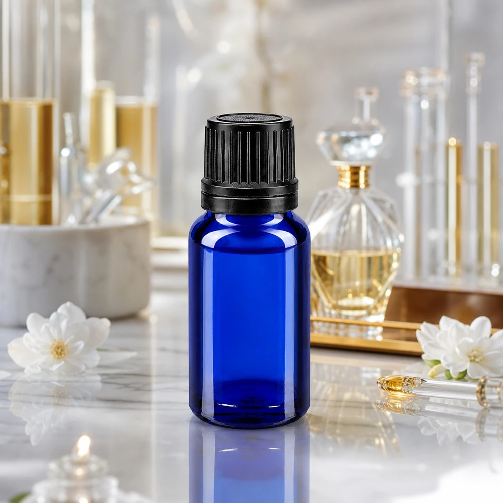 Apoteksflaske blå 10ml dryp v. Pr. 1mm sort OV Blå 10 ml glasflaske med sort originalitetslukning på marmor blandt parfumeflasker