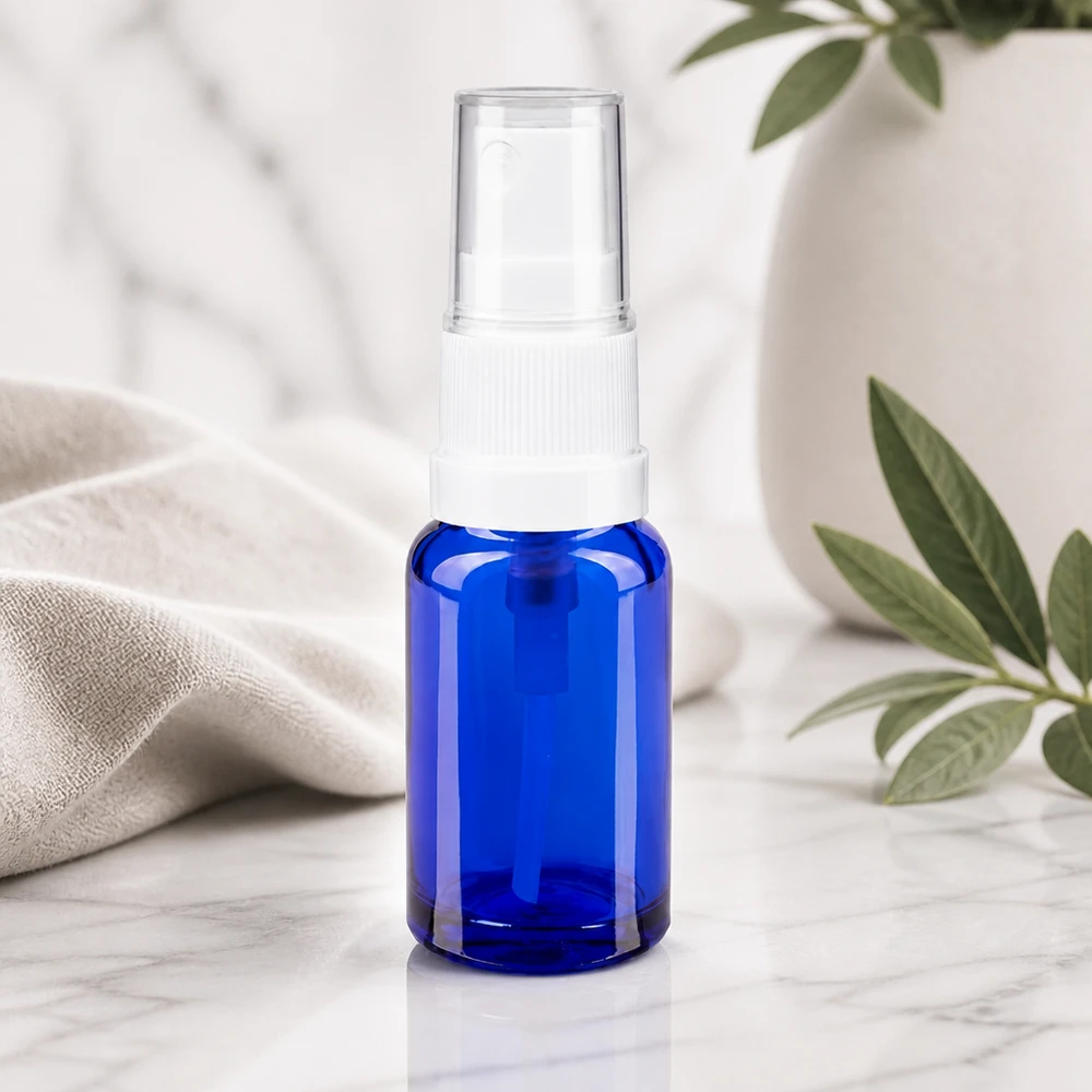 Apoteksflaske blå 10ml spraytop hvid Blå 10 ml apotekerflaske med standardforstøver i hvidt og gennemsigtig beskyttelseshætte